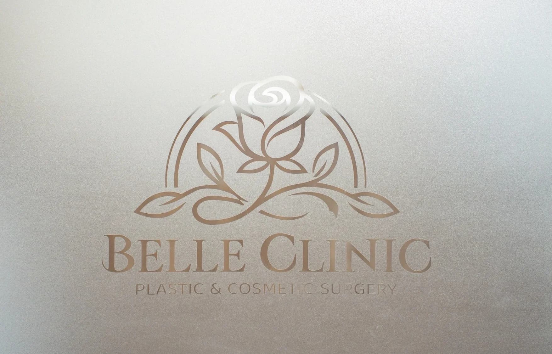 すりガラスにエッチングされたBELLE CLINICのロゴ